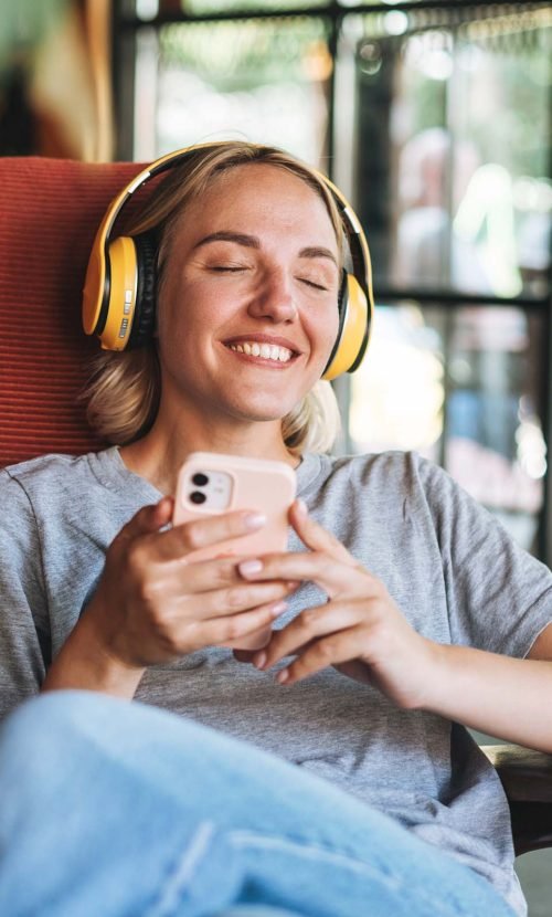 young-happy-woman-with-close-eyes-in-yellow-headph-C2TKXC2.jpg